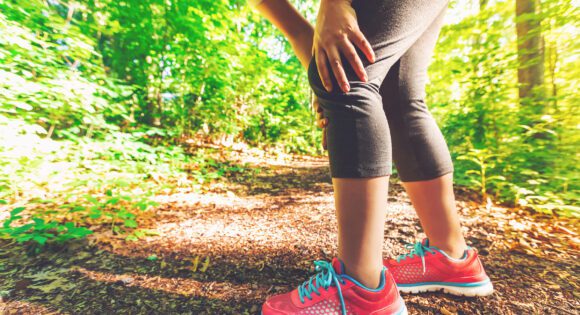 Woman running with knee pain or soreness