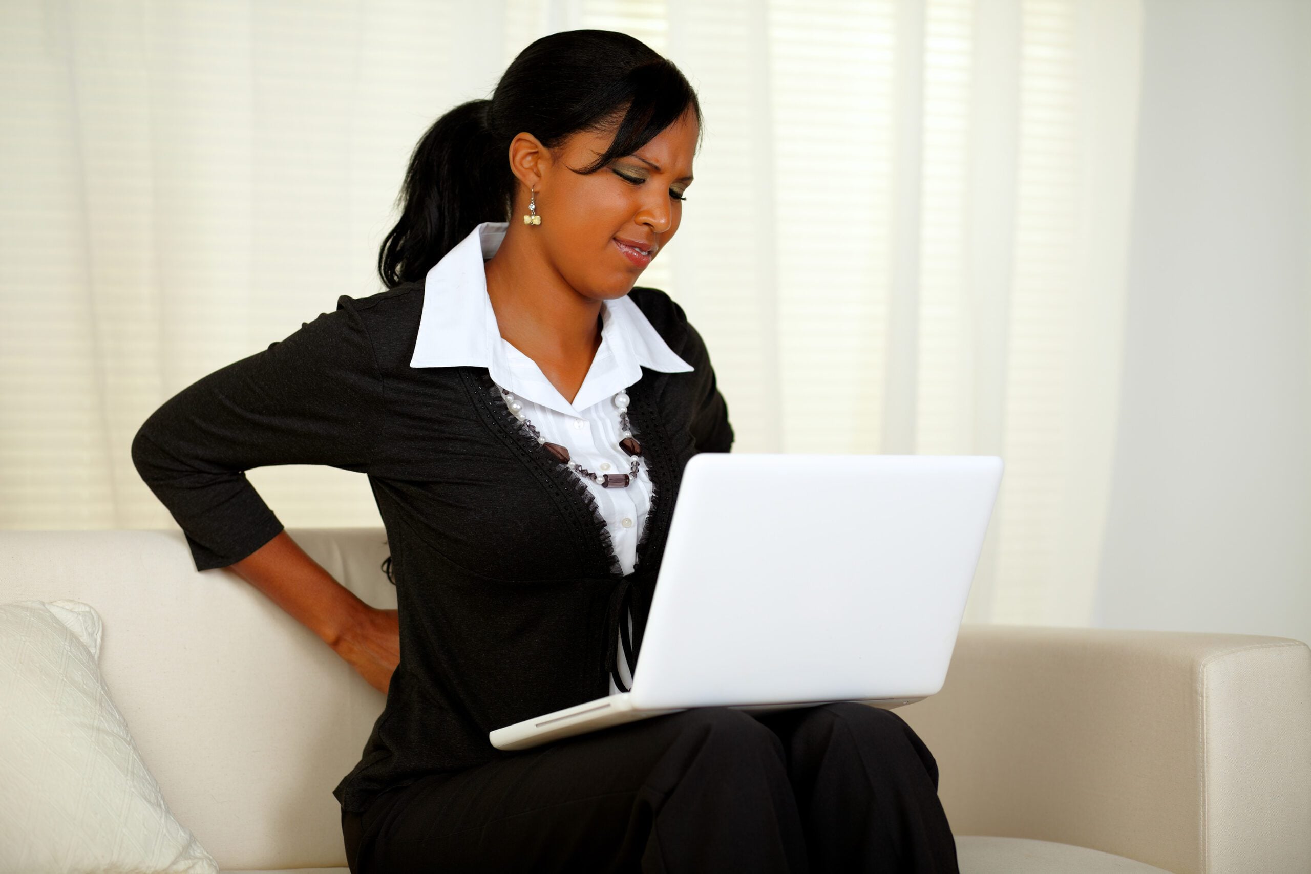 Woman with back pain at a computer