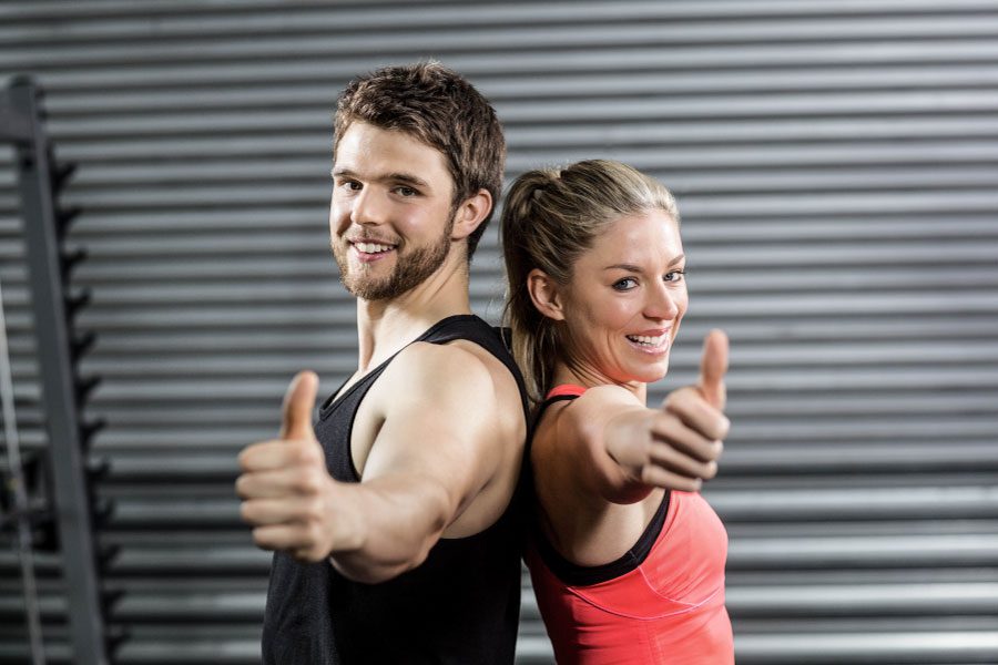 Athletic young woman and man give thumbs up about Epic Physical Therapy