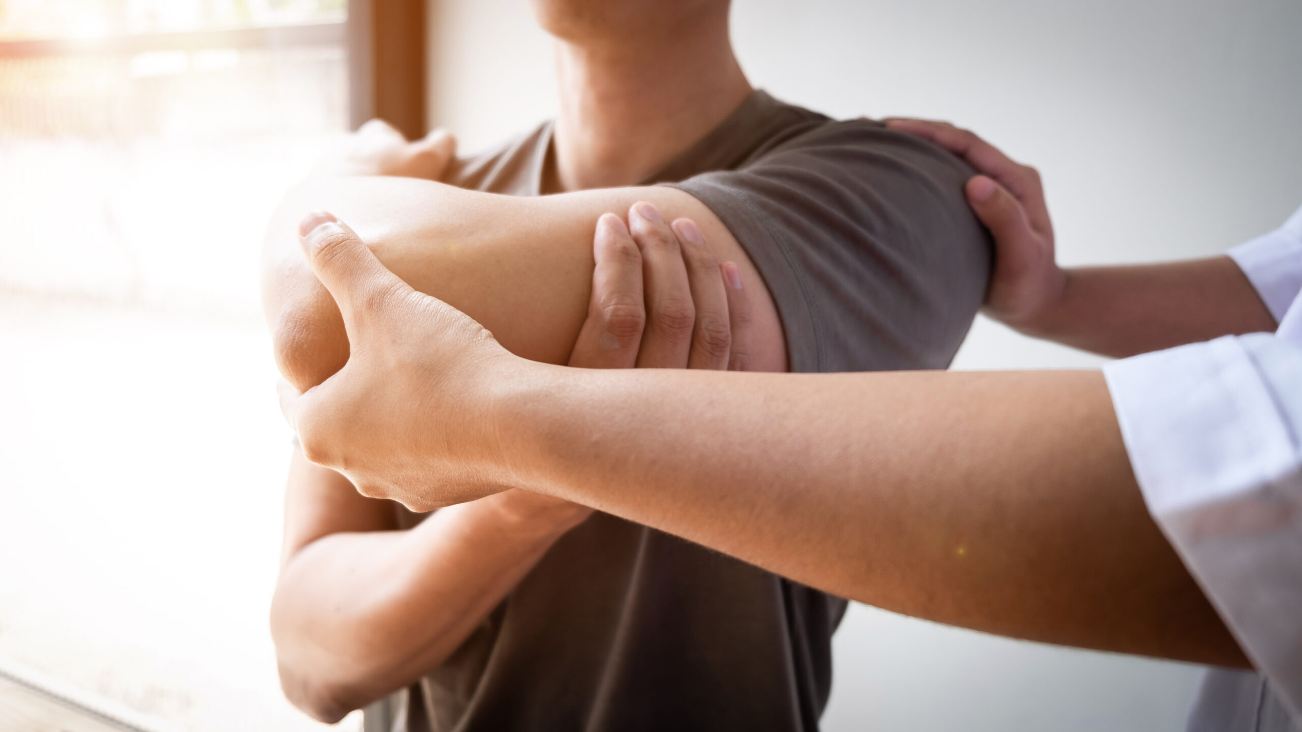 Therapist treating a male injured by rotator cuff