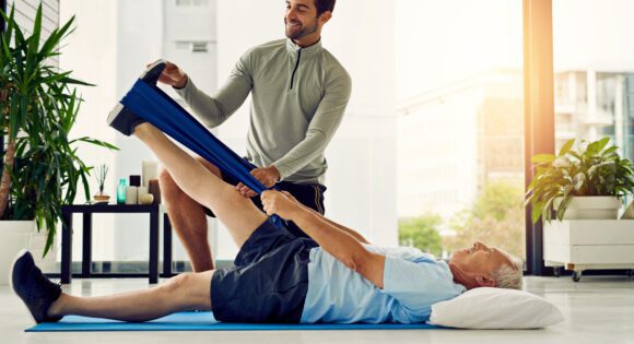 Physical therapist helping a patient stretch his leg