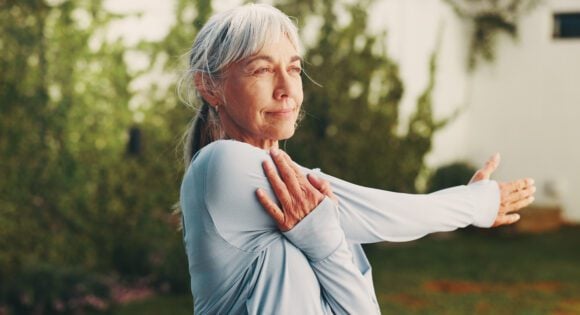 Middle aged woman stretching her arm